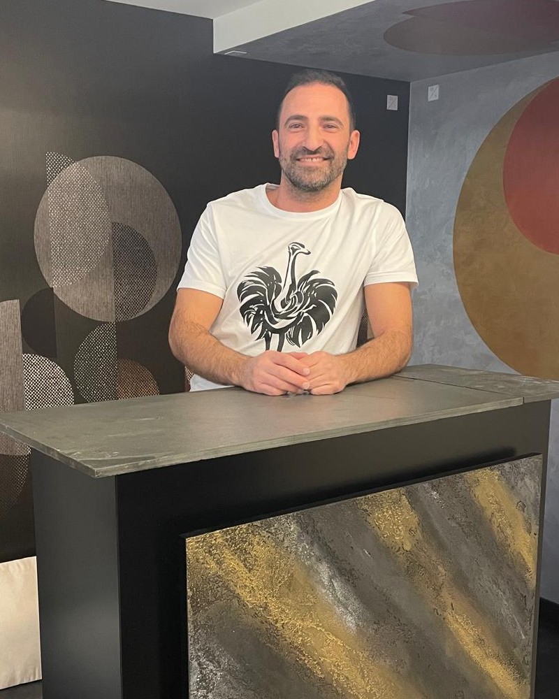 Edler Marmorino-Putz in Gold- und Anthrazittönen an einer Empfangstheke